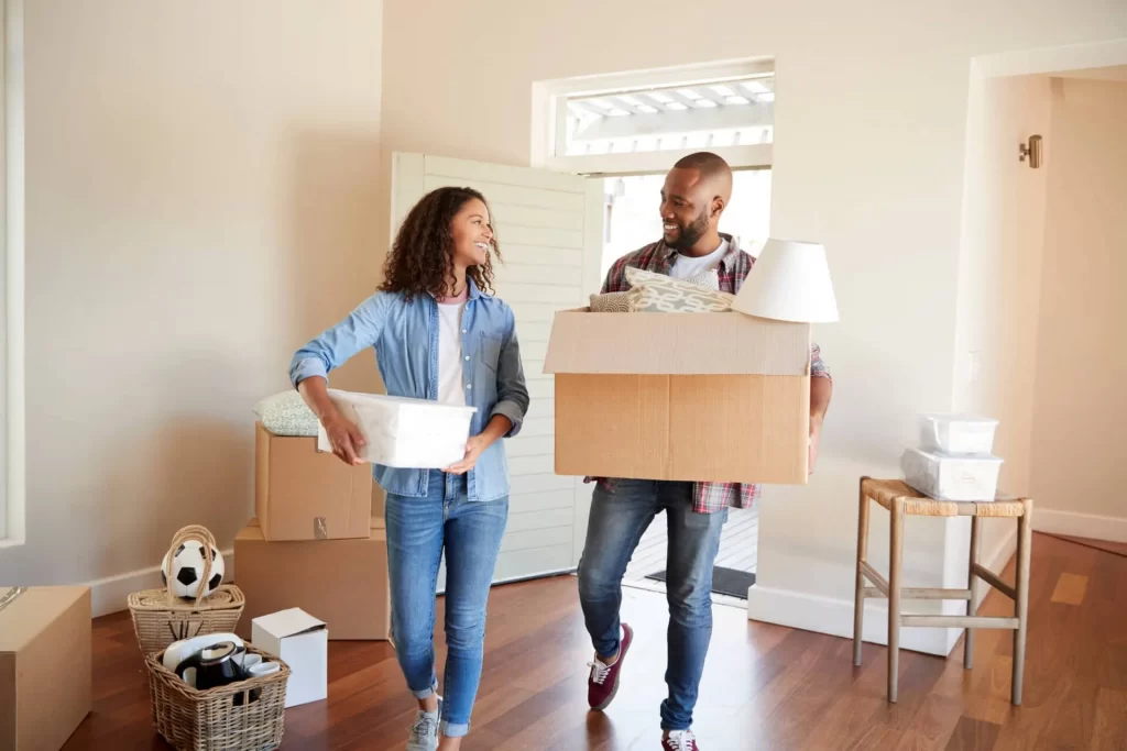 Millennial couple moving into Arcadia home carrying boxes