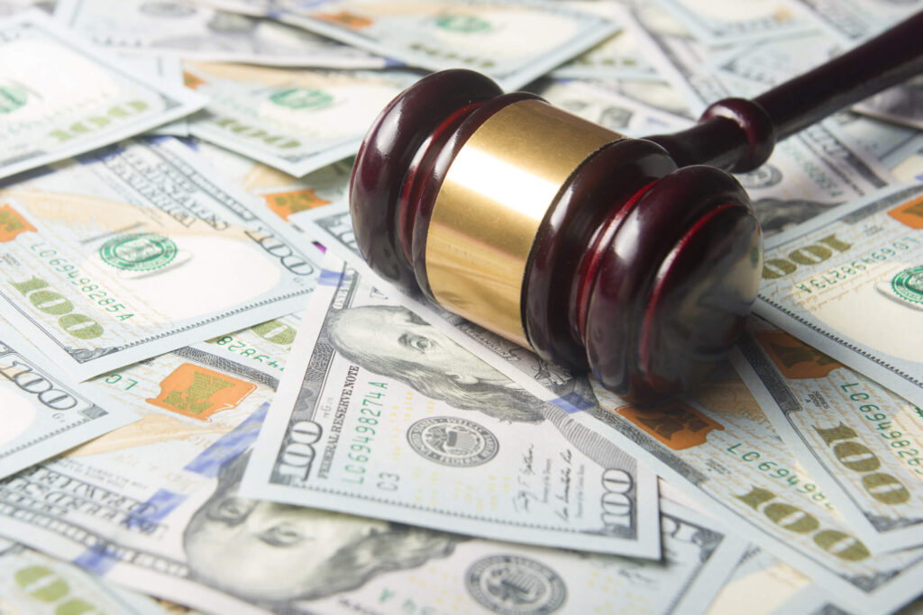 A gavel on a pile of cash to represent the costs of being sued by a tenant. 